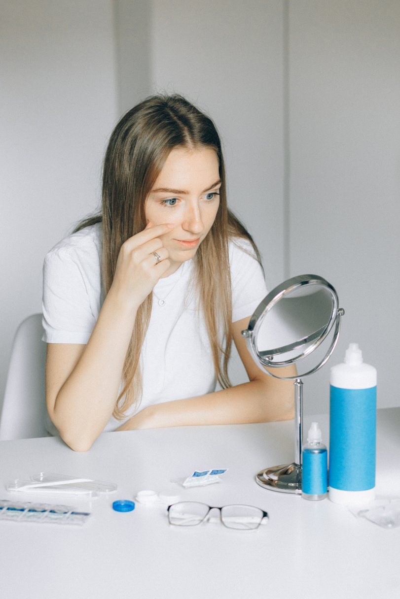 Woman putting Contact Lens on her Eyes