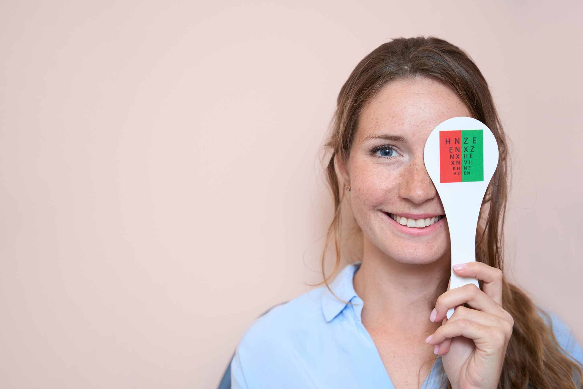 Laughing female is checking her visual acuity